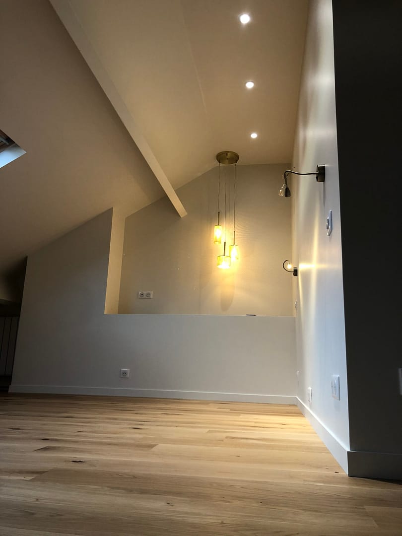 Intérieur des combles aménagés avec parquet naturel et éclairage moderne, projet réalisé à Fontenay sous Bois par Design & Couleurs.