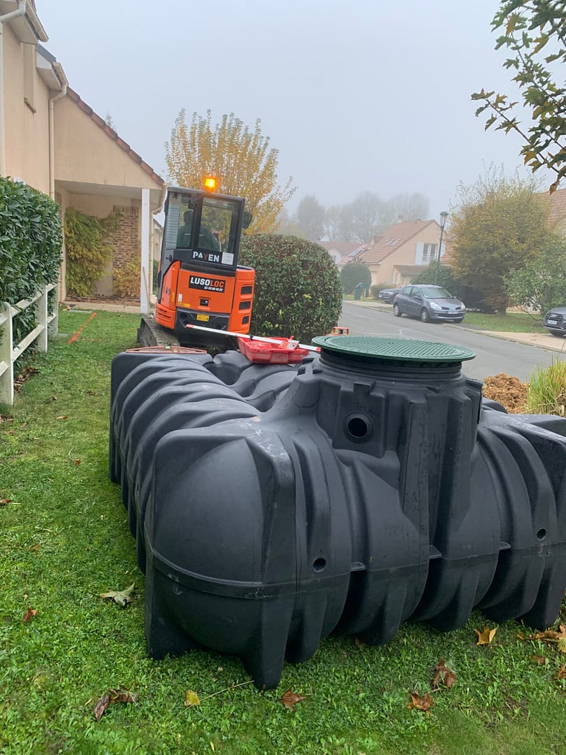 Installation en extérieur d'une cuve de récupération d'eau de 5000 litres avec un engin de chantier à Ozoir la Ferrière, par Design & Couleurs.